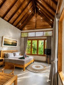 a bedroom with a bed and a large window at LUV-Balian in Balian +49 photos