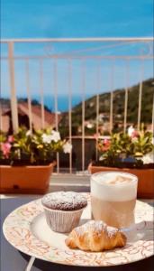 a plate with a cupcake and a drink on a table at Le Perseidi in Agerola