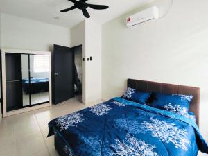 a bedroom with a blue bed and a ceiling fan at 25 Homestay Pulai in Johor Bahru