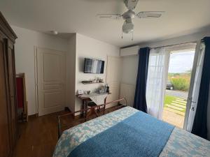 a bedroom with a bed and a sliding glass door at Villa Les Hortensias B&B in Arcangues