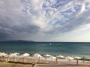 a beach with umbrellas and a boat in the water at Trifilli in Lourdata