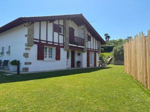 a house with a fence and a grass yard at Villa Les Hortensias B&B in Arcangues