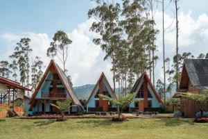 a group of houses with trees in the background at The Cabin Artana By ARBA in Palayangan