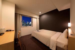 Hotel Asia Center of Japan في طوكيو: غرفة نوم بسرير ومكتب ونافذة
