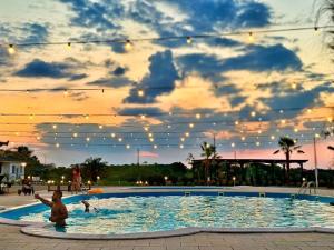 a child standing in a swimming pool at a resort at KIBO Boutique in Frumuşani