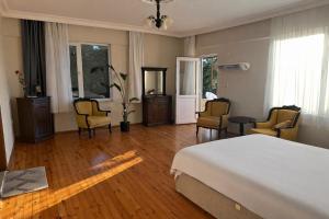a bedroom with a bed and chairs and a table at Nature Gate Airport Hotel in Arnavutköy