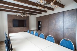 a conference room with a long table and blue chairs at Hotel in der Mühle in Werdau