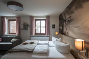 a bedroom with a bed and a chair and windows at Hotel in der Mühle in Werdau +107 photos