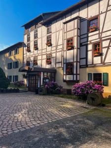 a large building with flowers in front of it at Hotel in der Mühle in Werdau