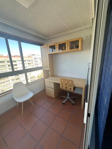 an office with a desk and a chair and a window at Apartamento Bamuxela in Vigo