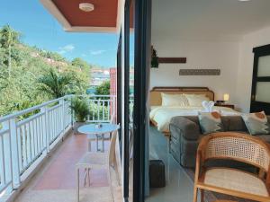 a bedroom with a bed and a balcony at Mr Oh in Phuket Karon in Ka Rorn
