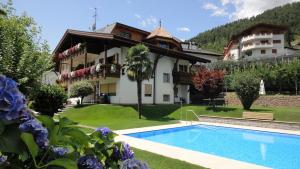 a villa with a swimming pool in front of a house at Ferienwohnungen Haus Christine in Rifiano
