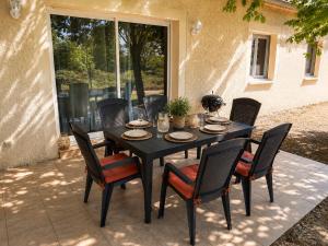 a black table and chairs on a patio at L'Ardétente - L'Instant Présent - Villa avec piscine privée Adults Only Ardèche in Lussas