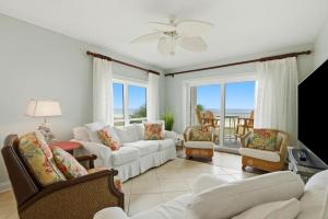 a living room with white furniture and a view of the ocean at Riviera Dunes 201 in Perdido Key