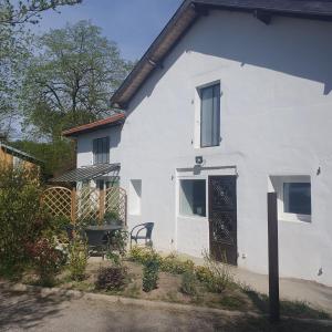 a white house with a black door and a chair at La forge in Hinx