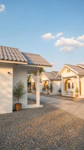 a row of white houses with a tree in a driveway at OneVillaResort in Ban Son Tap Tao