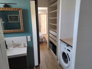 a bathroom with a sink and a washing machine at La forge in Hinx +2 photos