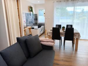 a living room with a couch and a table with chairs at L'Ardétente - Le cosy, Piscine et SPA en Ardèche, Adults only in Lussas