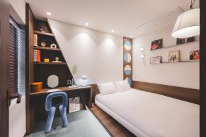 a bedroom with a bed and a desk and a chair at BUSAN Stay 404 in Busan