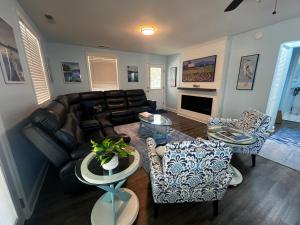 a living room with a leather couch and chairs at Dockside Dreamz 2 with beach & dock in Clarksville
