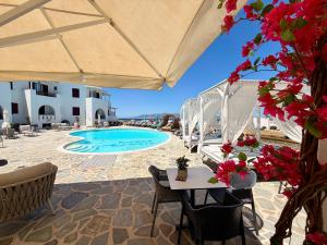 a resort with a pool and tables and chairs at Naxos Mare in Agia Anna Naxos