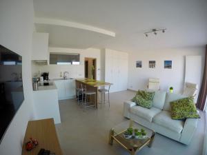 een woonkamer en een keuken met een bank en een tafel bij Apartment S7 in Oostende