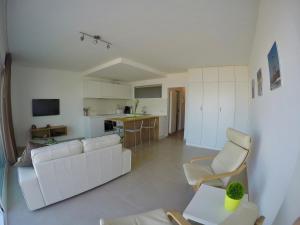 ein Wohnzimmer mit weißen Möbeln und eine Küche in der Unterkunft Apartment S7 in Ostende