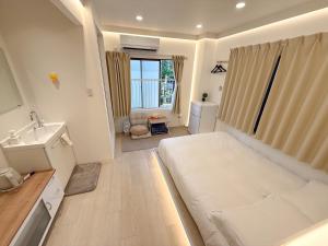 a bedroom with a large white bed and a sink at RShotel in Tokyo