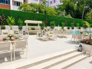 a patio with tables and chairs and a pool at Alpek Hotel Antalya - Lara in Antalya