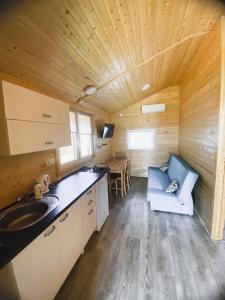 a kitchen in a log cabin with a sink and a table at Pirat Gąski in Gąski +62 photos