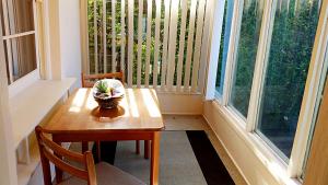 a table and chairs in a room with windows at Deco Family House in Melbourne