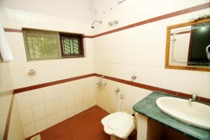 a bathroom with a toilet and a sink at Landmark INN in Kāsaragod +7 photos