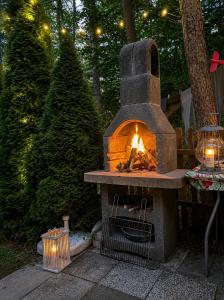 a stone oven with a fire in it next to a christmas tree at Merylula - Domek nad jeziorem in Przydwórz