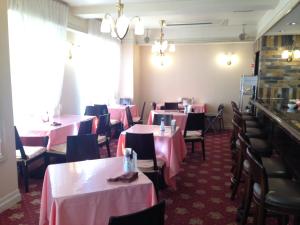 un comedor con mesas, sillas y manteles rosados en Creston Hotel en Iwaki