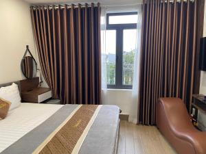 a hotel room with a bed and a window at Hotel Thái Lan in Hai Phong
