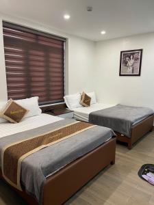 a room with two beds and a window at Hotel Thái Lan in Hai Phong