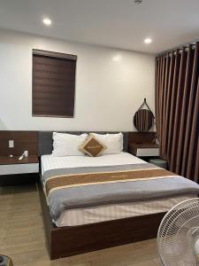 a bedroom with a large bed with a window at Hotel Thái Lan in Hai Phong