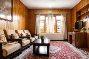 a living room with a couch and a tv at The Bilt farmhouse in Srinagar