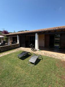 a house with two lawn chairs in the yard at Villino Giò - Residence Abba Urci in Tertenìa +34 photos