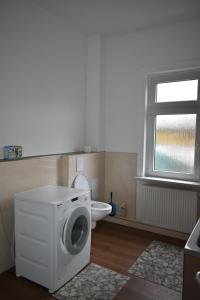 a washing machine in a bathroom with a toilet at Revant Monteurzimmer Haus WE 3 in Arnstadt
