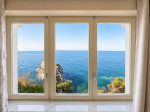 a room with three windows looking out at the ocean at Villa Cliff in Aspra +26 photos