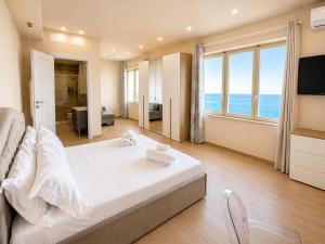 a bedroom with a bed and a view of the ocean at Villa Cliff in Aspra