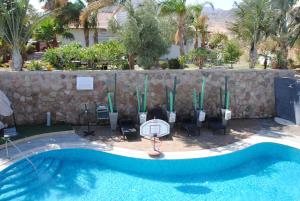 a pool at a resort with a basketball hoop and chairs at Villa Riviera Eilat in Eilat