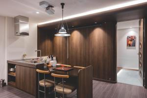 a kitchen with a bar with stools and a sink at BUSAN Stay 404 in Busan +21 photos