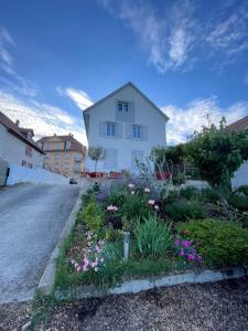 a house with a garden with flowers in the street at Le Cosy Strasbourg calme et confortable avec parking gratuit, 10 mn du Parlement Européen et du Wacken de 1 à 24 voyageurs in Schiltigheim