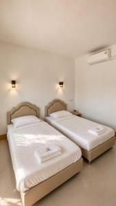 two beds sitting next to each other in a room at OneVillaResort in Ban Son Tap Tao