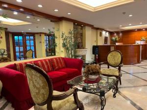 a living room with a red couch and chairs at The Manor Hotel in Davao City