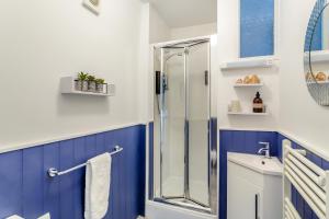 a bathroom with blue and white walls and a shower at The Haven, Leyburn in Leyburn +13 photos