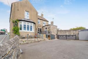 a large brick house with a fence in front of it at The Haven, Leyburn in Leyburn
