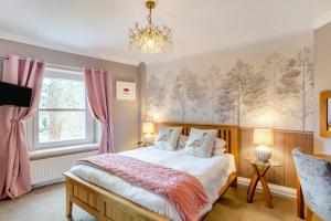 a bedroom with a bed with pink curtains and a chandelier at The Haven, Leyburn in Leyburn